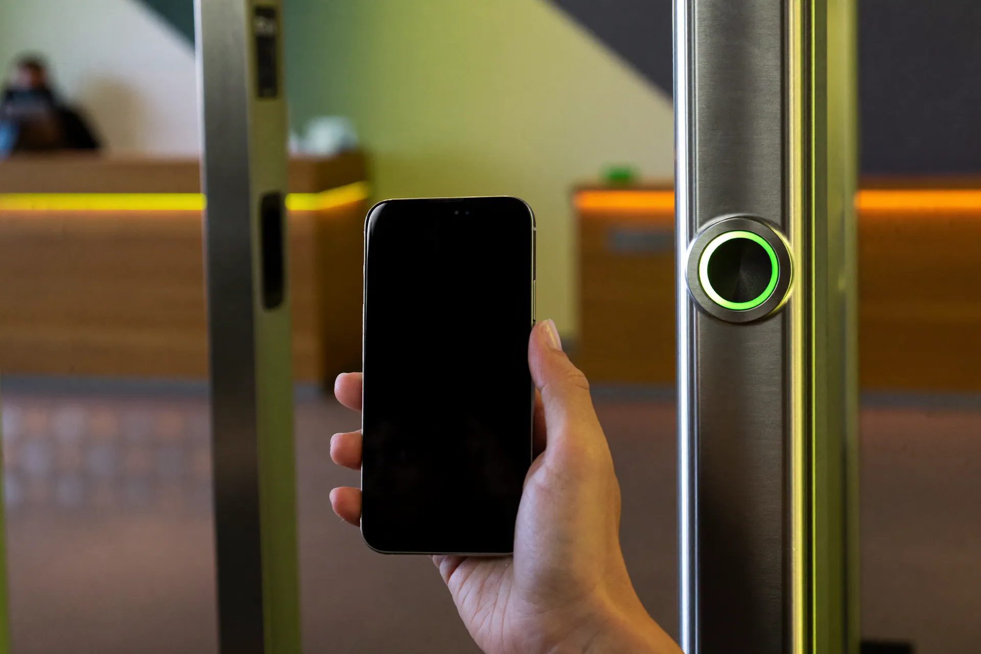 Cliente che passa la tessera QR dal telefono al lettore all'ingresso del centro